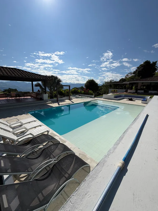 Piscina y asoleadoras de La Juana con vista panorámica a la cordillera