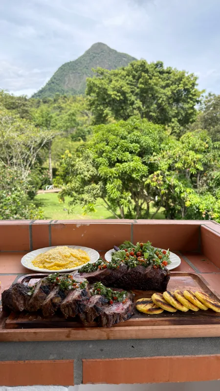 Mesa servida con asado campestre y almuerzo tradicional con vista franca al Cerro Tusa