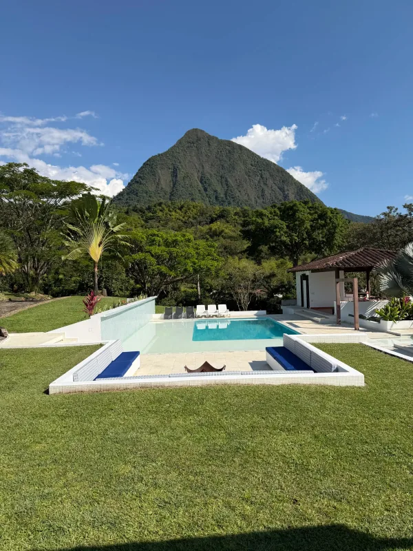 Piscina infinita y asoleadoras en finca de lujo en Antioquia con vista panorámica a las montañas