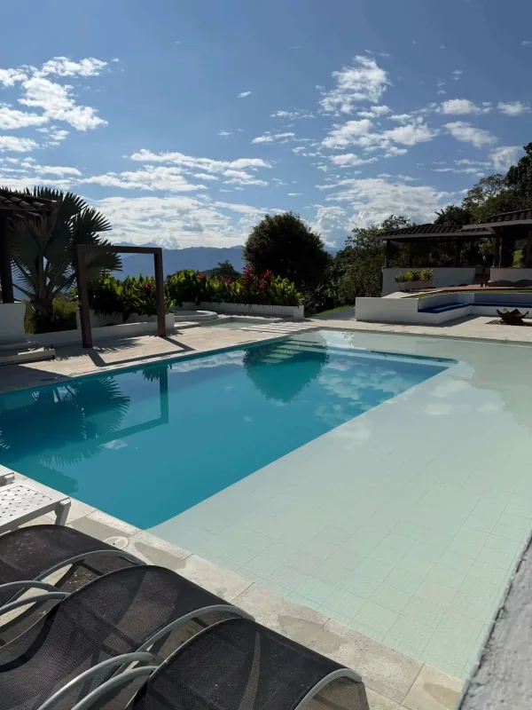 Piscina panorámica y zona de asoleadoras de La Juana en un día despejado