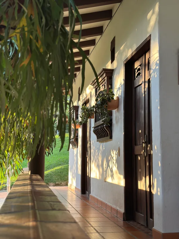 Corredor colonial y puertas de las suites en La Juana iluminadas por el atardecer