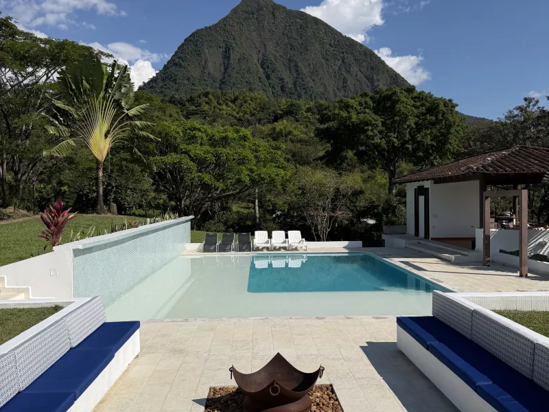 Piscina con fogata en el centro de la finca, plan de vacaciones familia Medellín con niños en La Juana Cerro Tusa