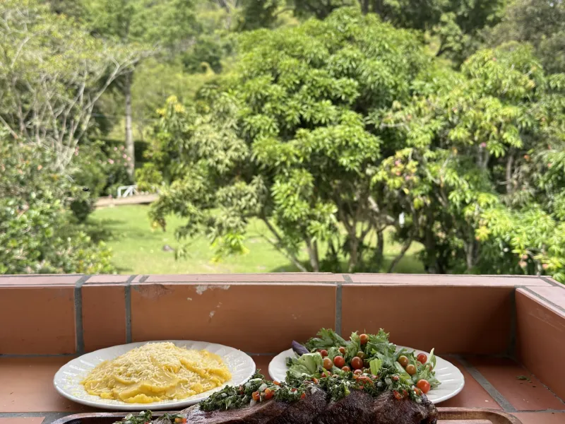Mesa de asado en la terraza con vista a la montaña, almuerzo familiar en vacaciones cerca de Medellín con niños